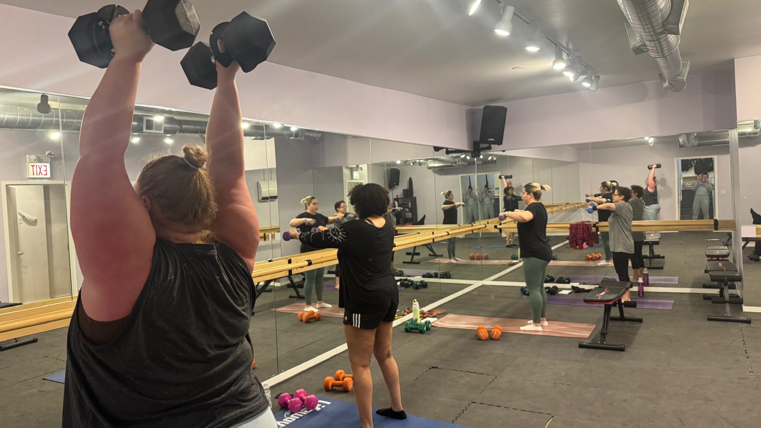 A Group Of Women Lifting Weights In A Gym